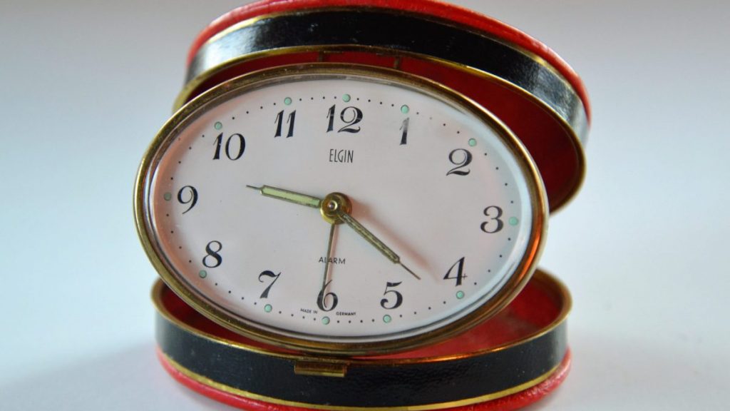 small circular clock with case